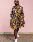 The model is wearing colorful flower print dress