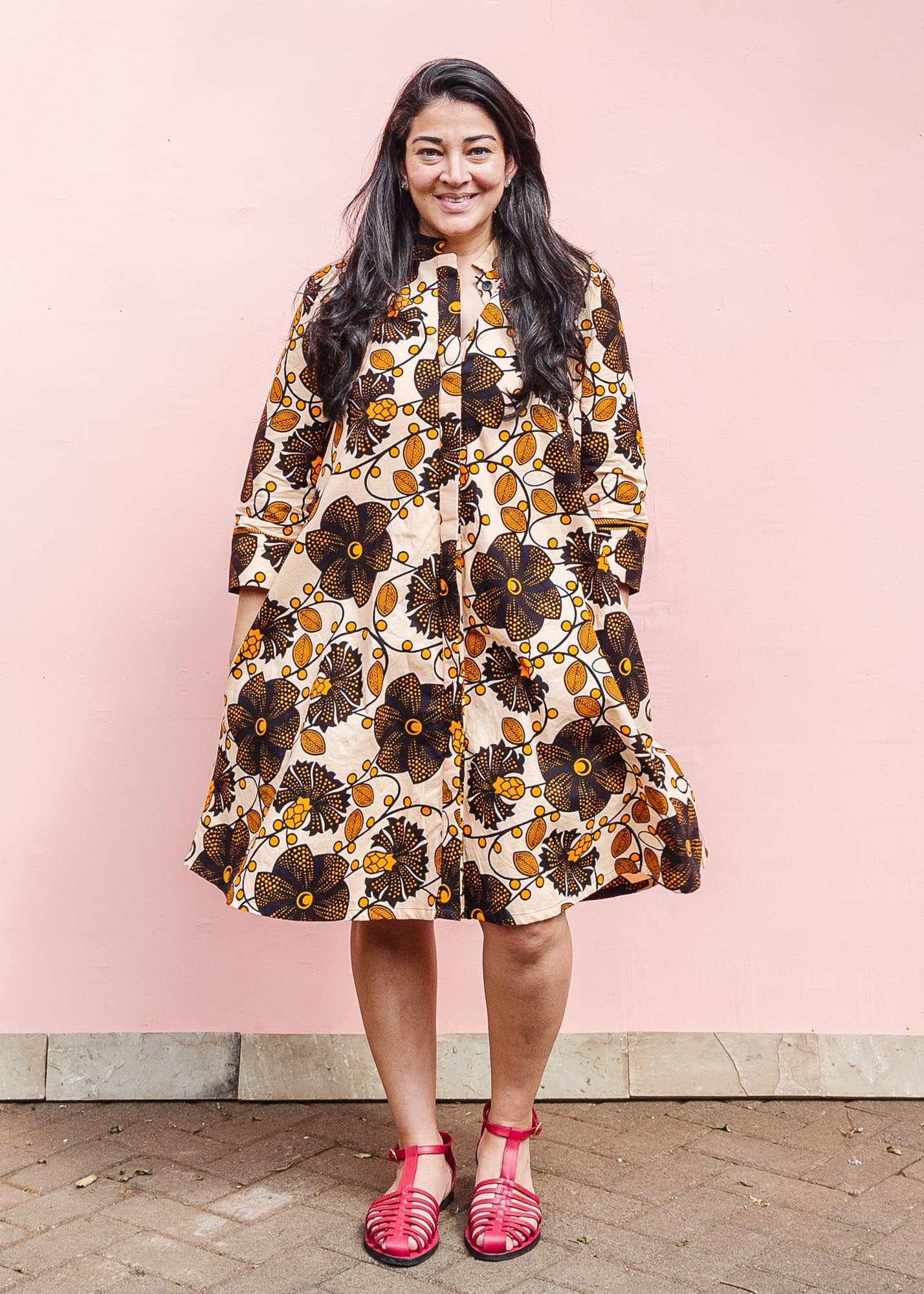 The model is wearing navy, black, off white, yellow flower print dress 