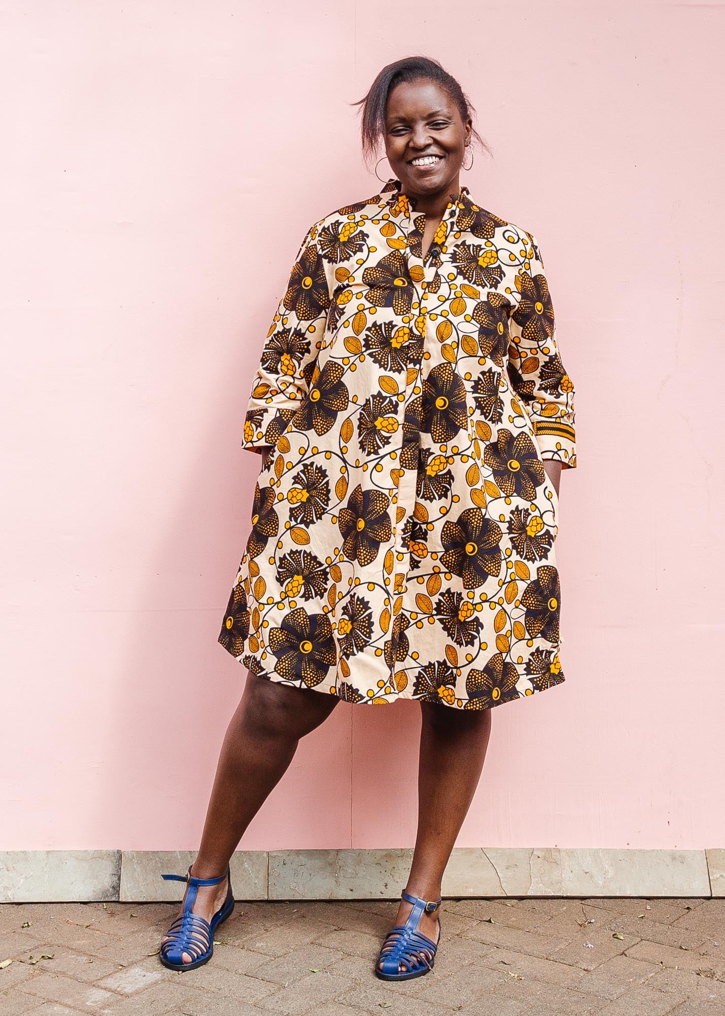 The model is wearing navy, black, off white, yellow flower print dress 