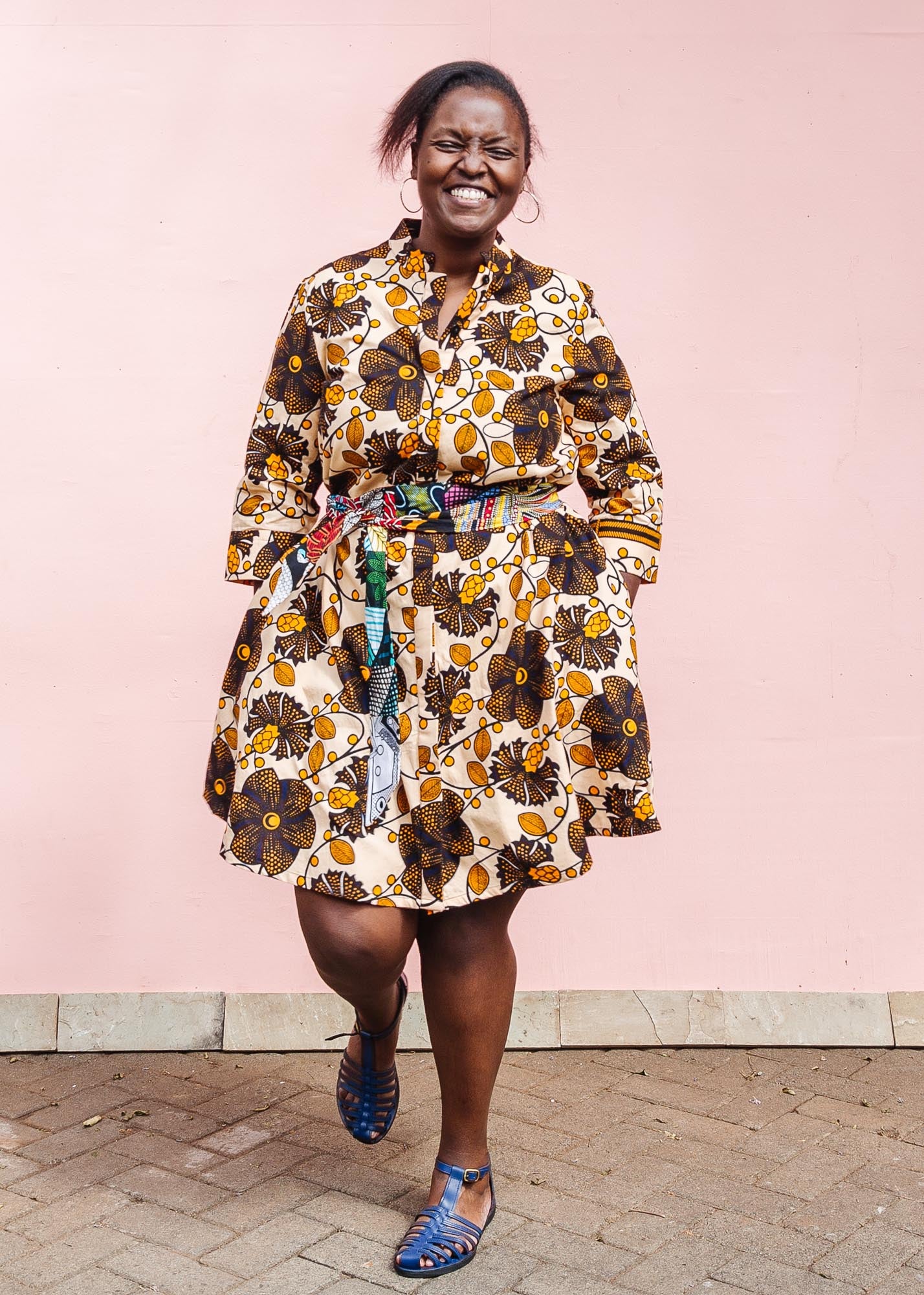 The model is wearing navy, black, off white, yellow flower print dress 