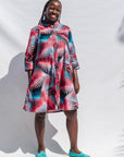 The model is wearing black, red, pink, light blue print dress