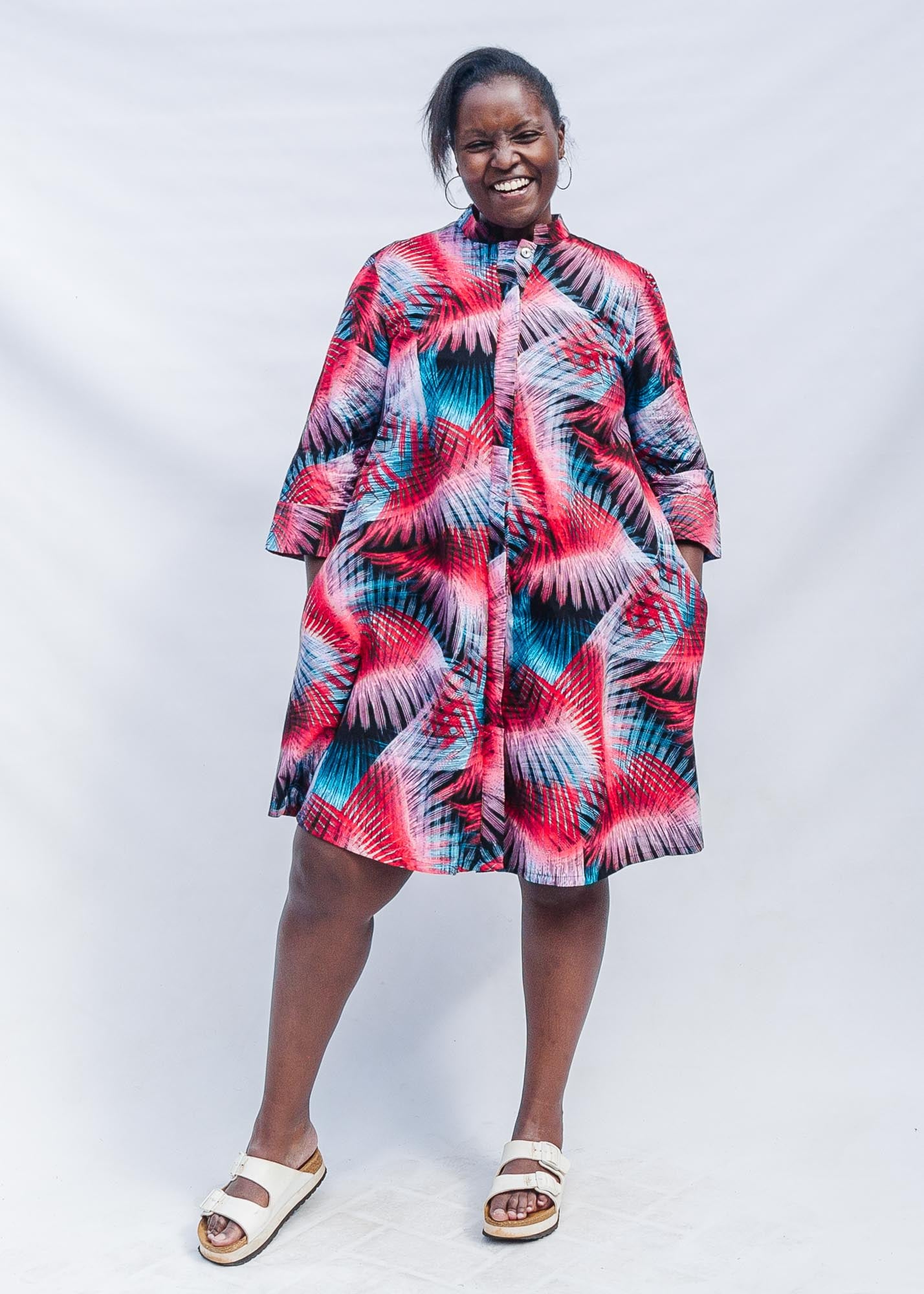 The model is wearing black, red, pink, light blue print dress