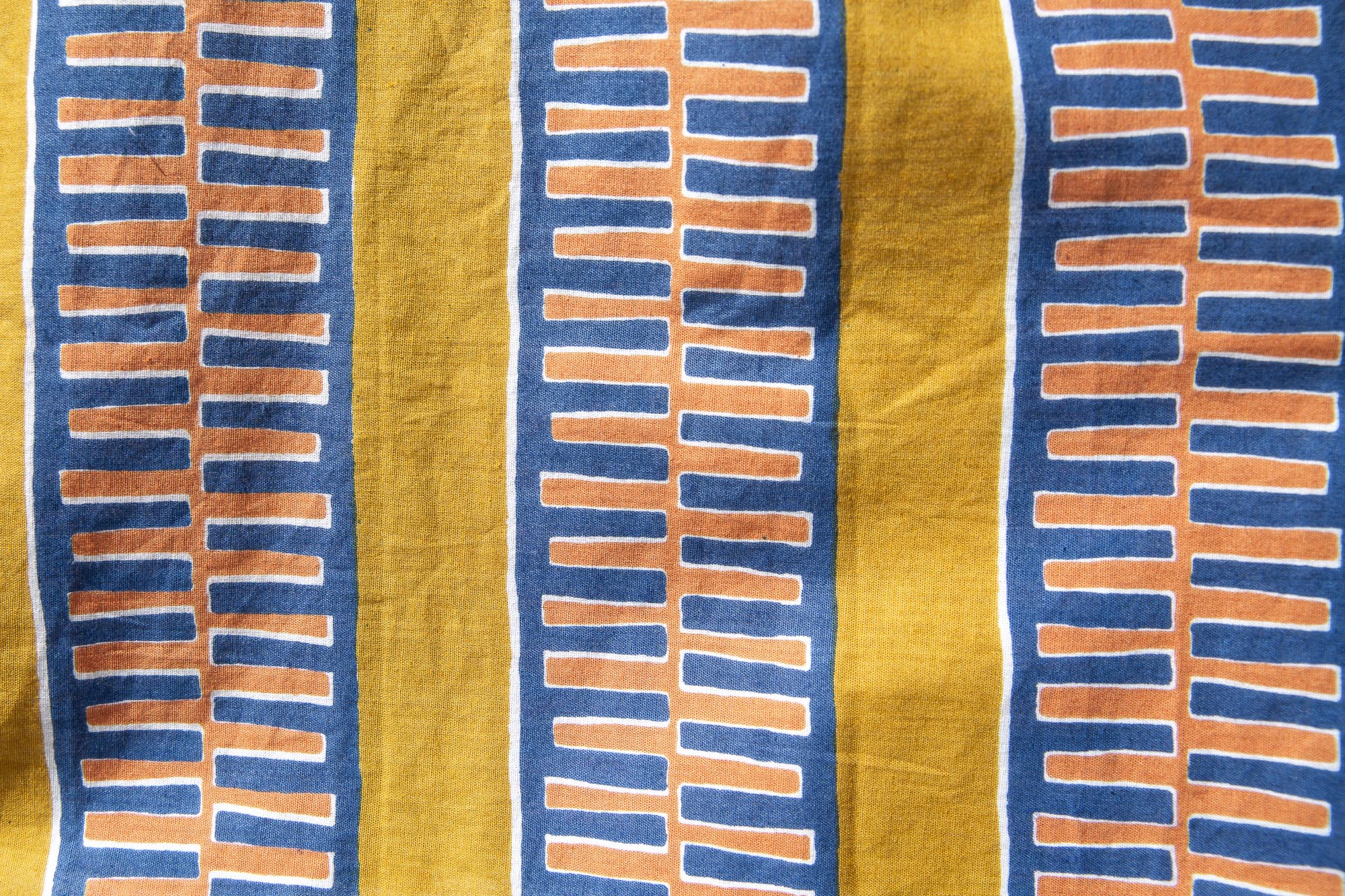 Close up display olive-yellow, blue, orange and white geometric printed shirt