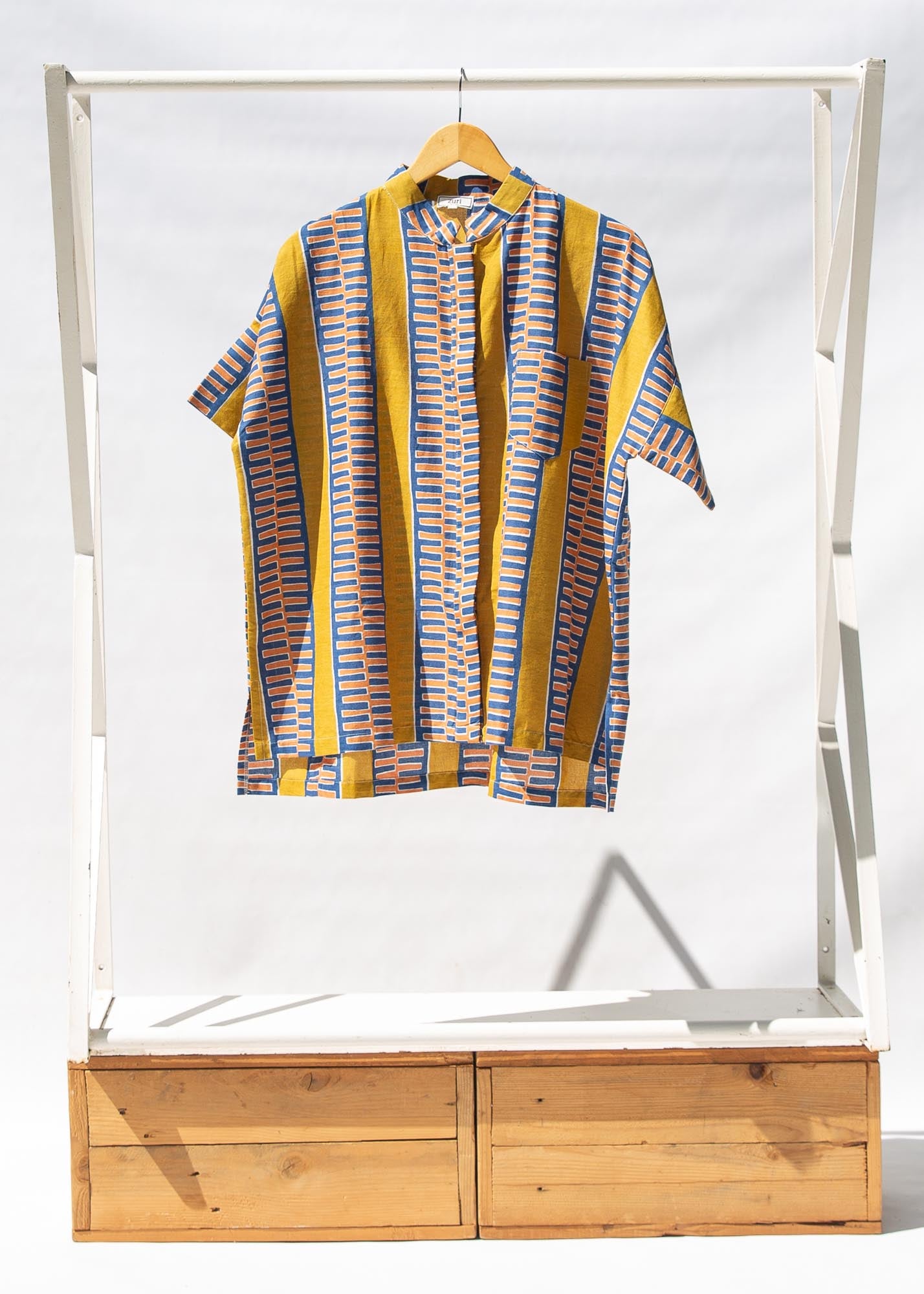 Display of olive-yellow, blue, orange and white geometric printed shirt