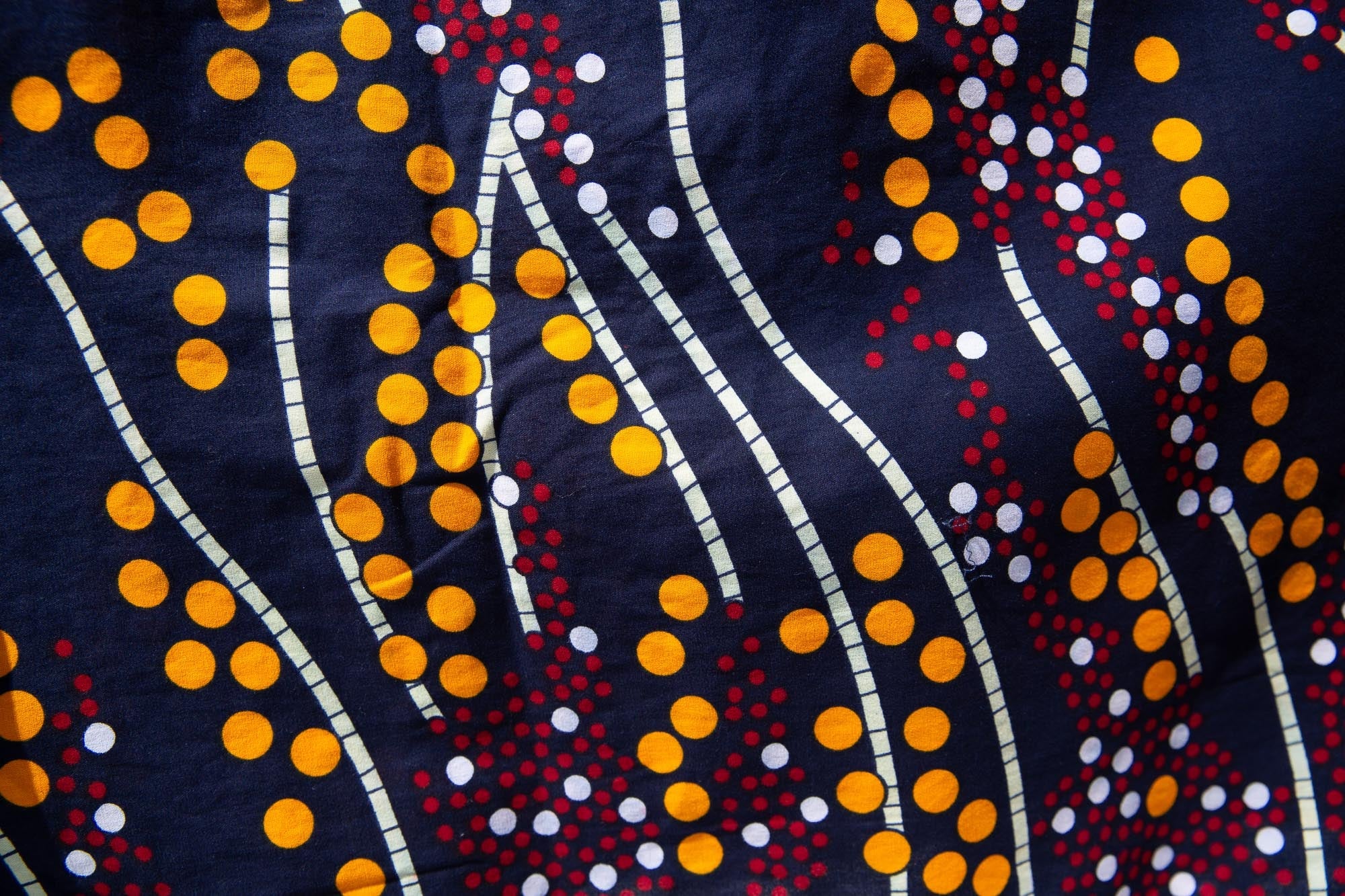 Close up display of navy, yellow, white, red print shirt