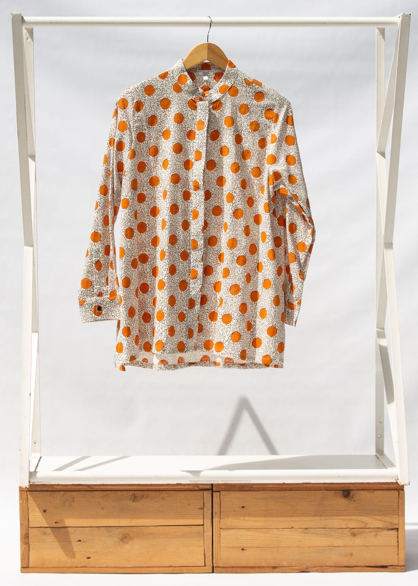 Display of white, orange, brown shirt