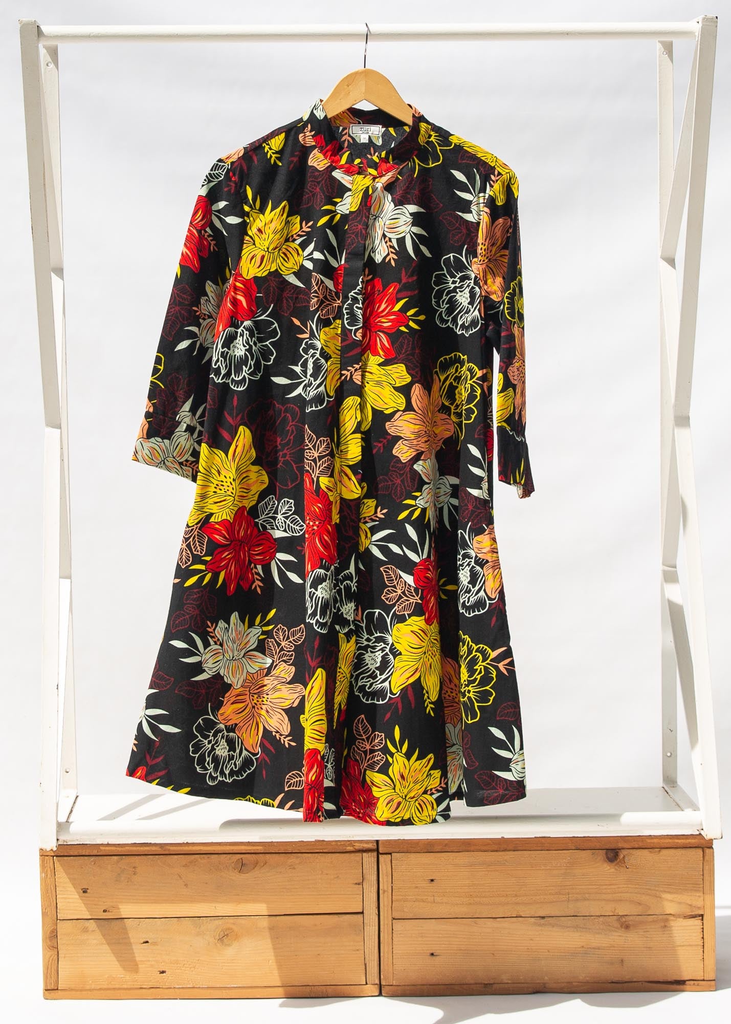 Display of black, white, red, yellow, peach floral print dress