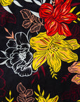 Close up display of black, white, red, yellow, peach floral print dress