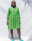 The model is wearing lichen green dress