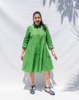 The model is wearing lichen green dress