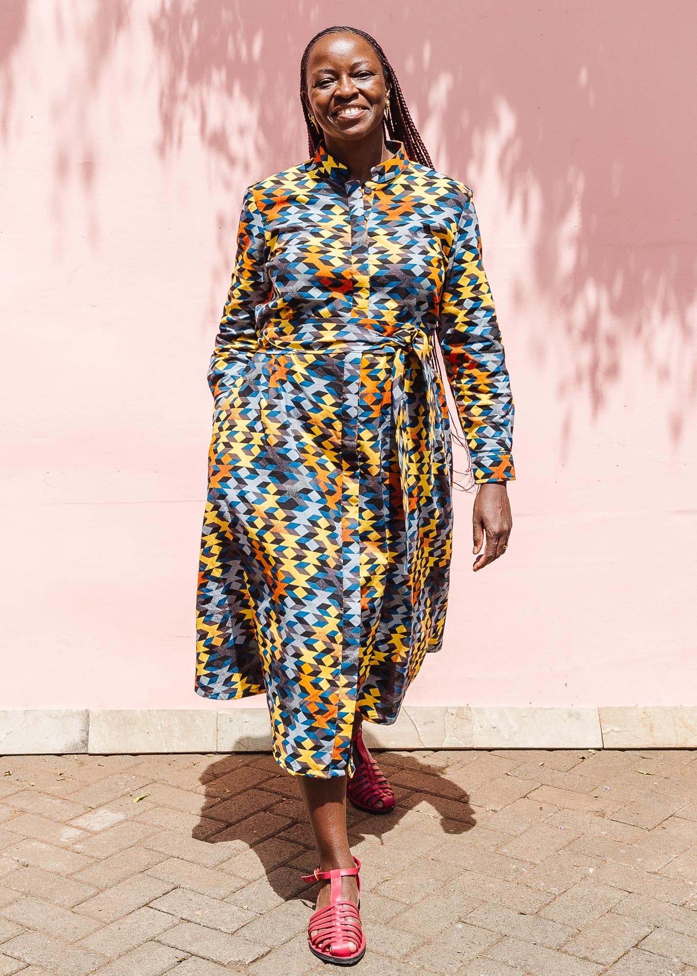 The model is wearing colorful geometric print dress