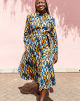 The model is wearing colorful geometric print dress