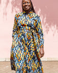 The model is wearing colorful geometric print dress