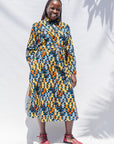 The model is wearing colorful geometric print dress