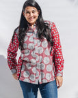 The model is wearing red, black, white print shirt