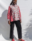 The model is wearing red, black, white print shirt