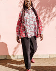 The model is wearing red, black, white print shirt