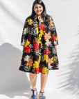 The model is wearing black, white, red, yellow, peach floral print dress