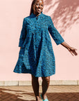 The model is wearing blue and black print dress