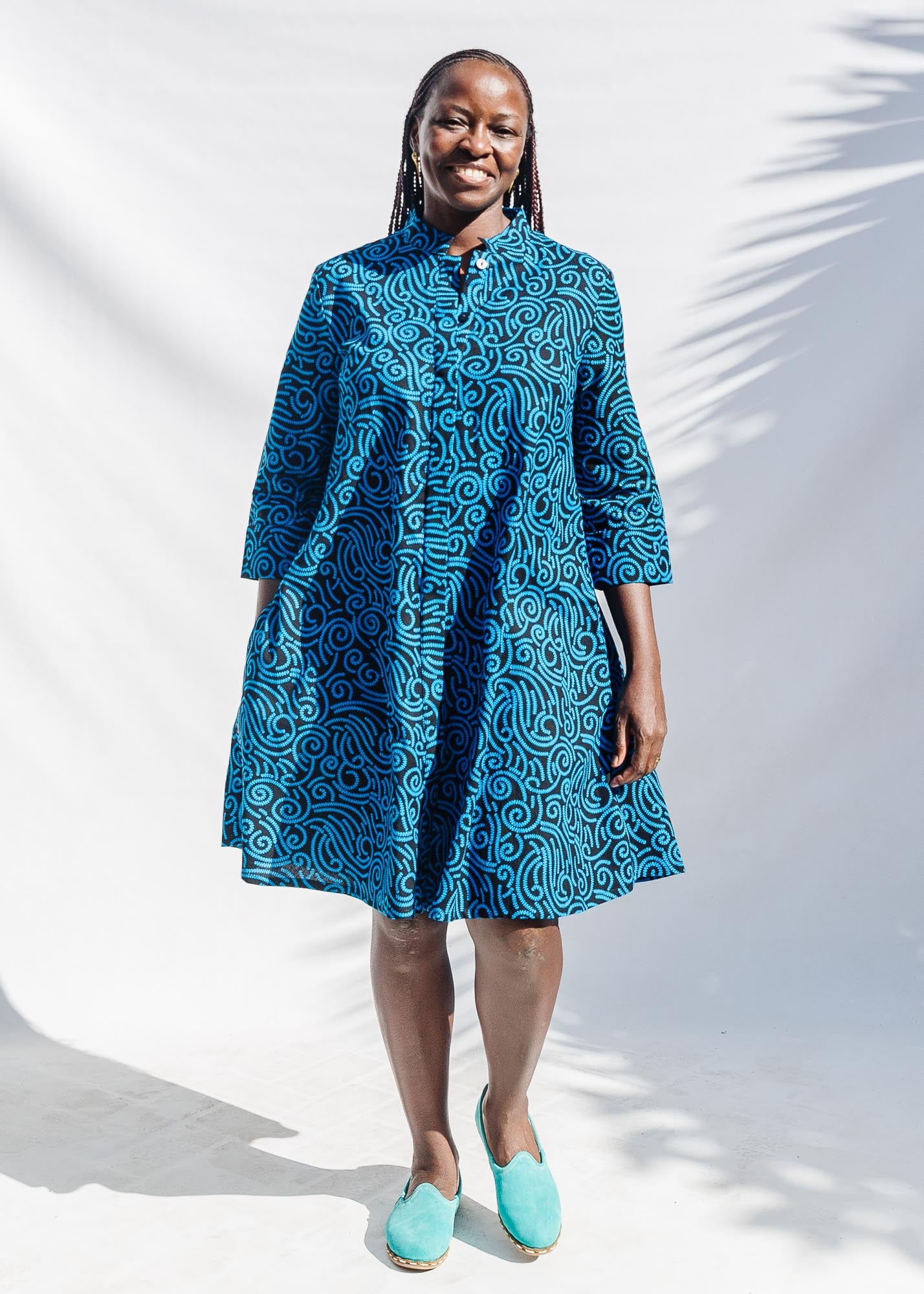 The model is wearing blue and black print dress