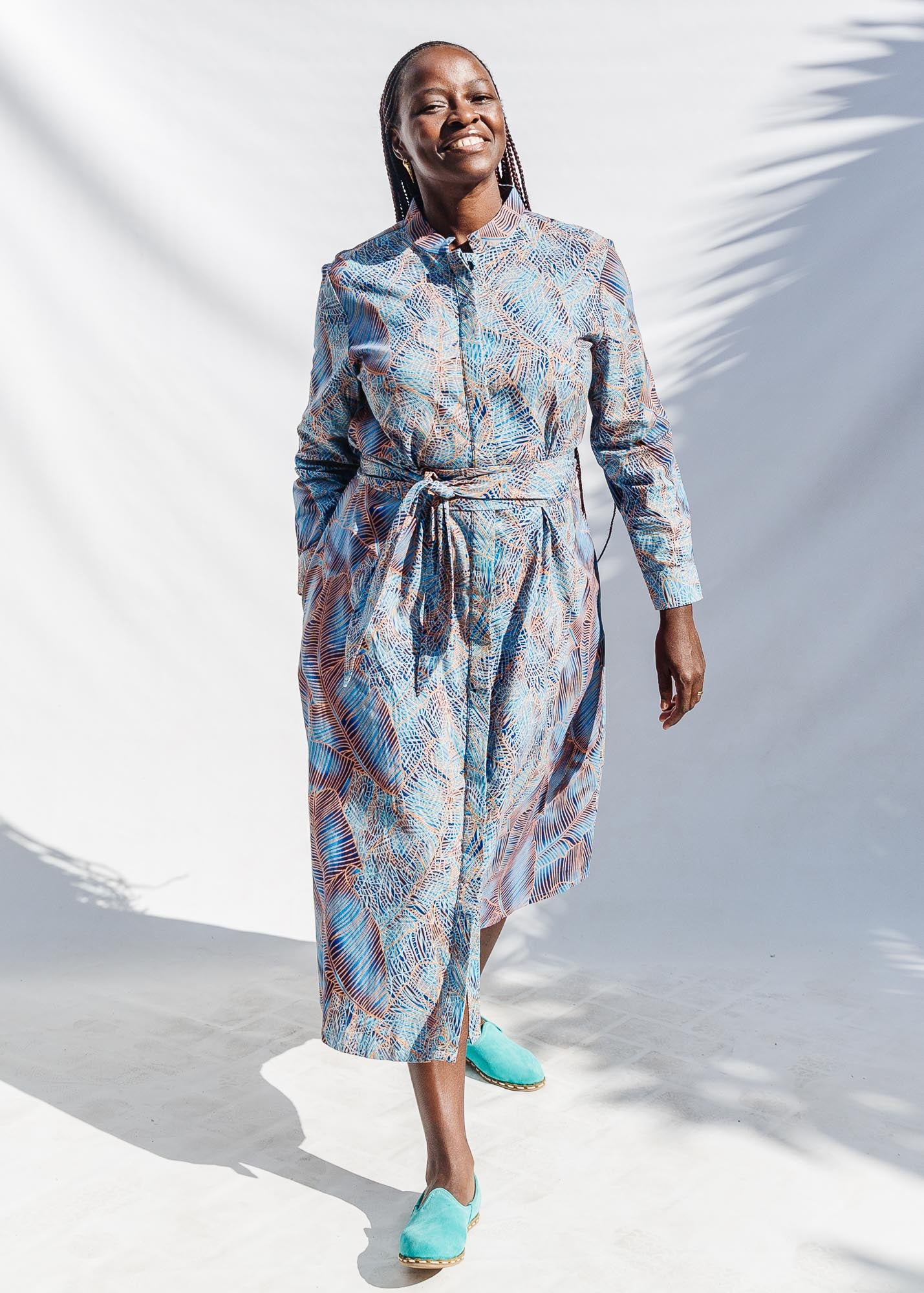 The model is wearing sky blue, blue, orange print dress