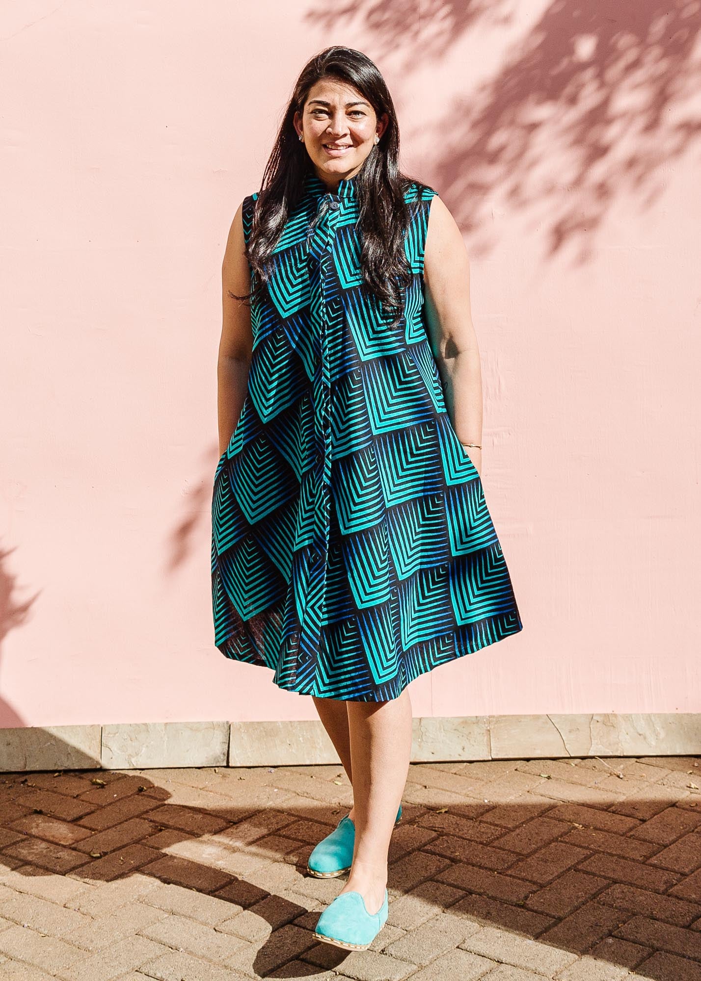 The model is wearing black, blue and aqua print dress