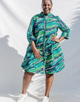 The model is wearing black, green, white, blue and aqua print dress