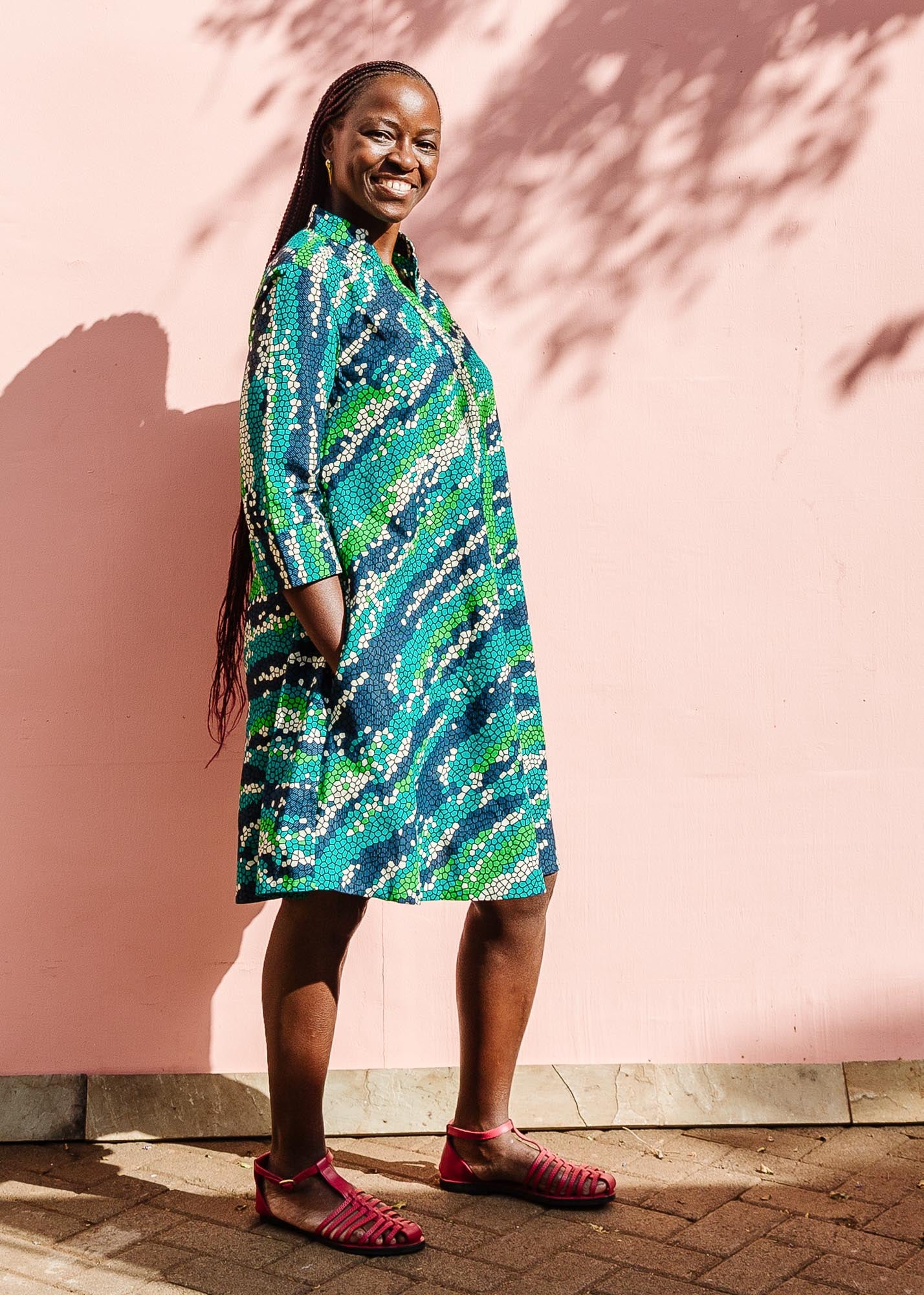 The model is wearing black, green, white, blue and aqua print dress