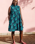 The model is wearing black, blue and aqua print dress