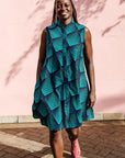 The model is wearing black, blue and aqua print dress