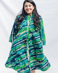 The model is wearing black, green, white, blue and aqua print dress