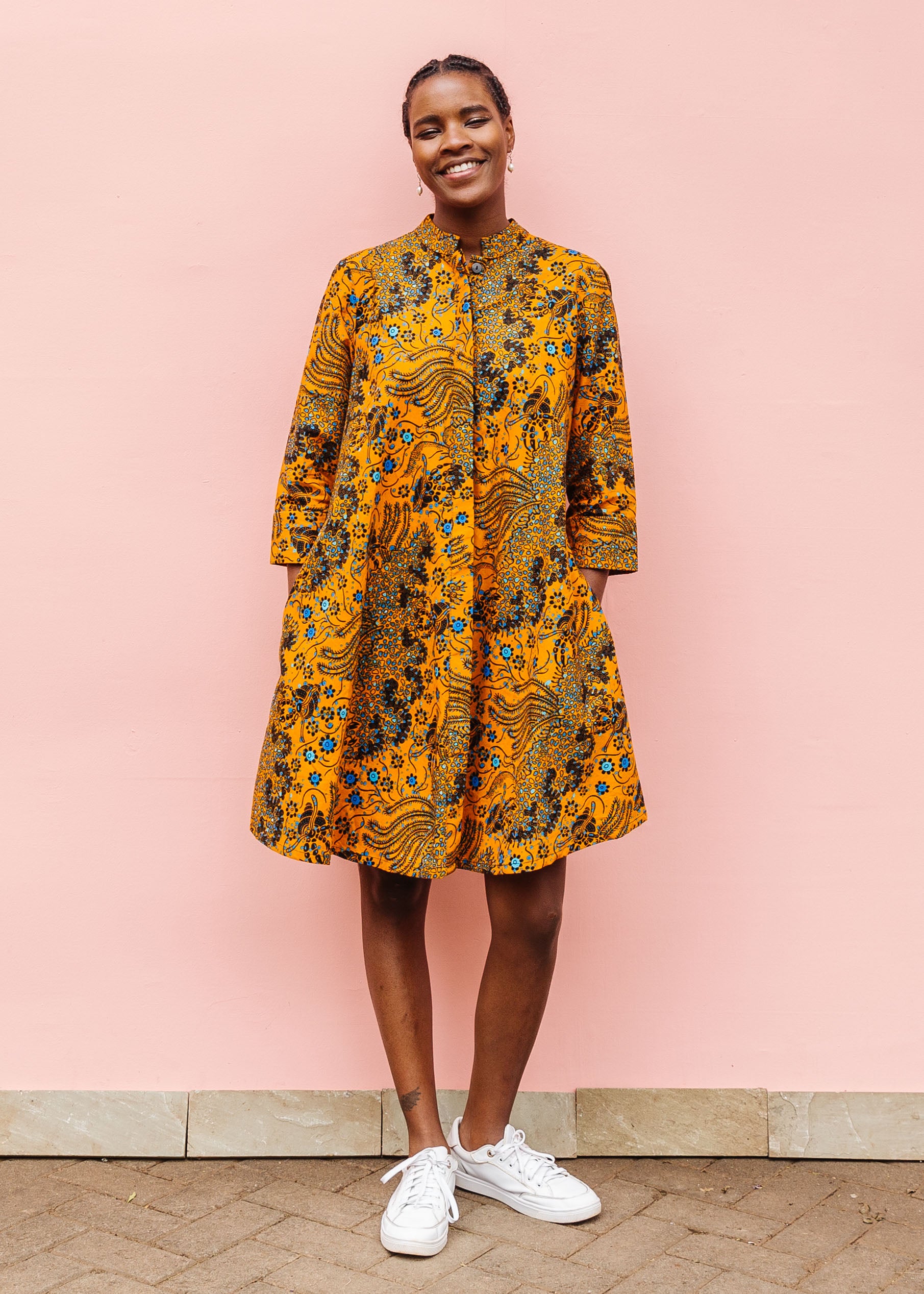 Model wearing caramel dress with blue and black small floral print.
