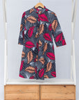 Display of navy dress with pink and peach feather print.