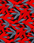 Close up display of red, black and gray leaf print dress, fabric.