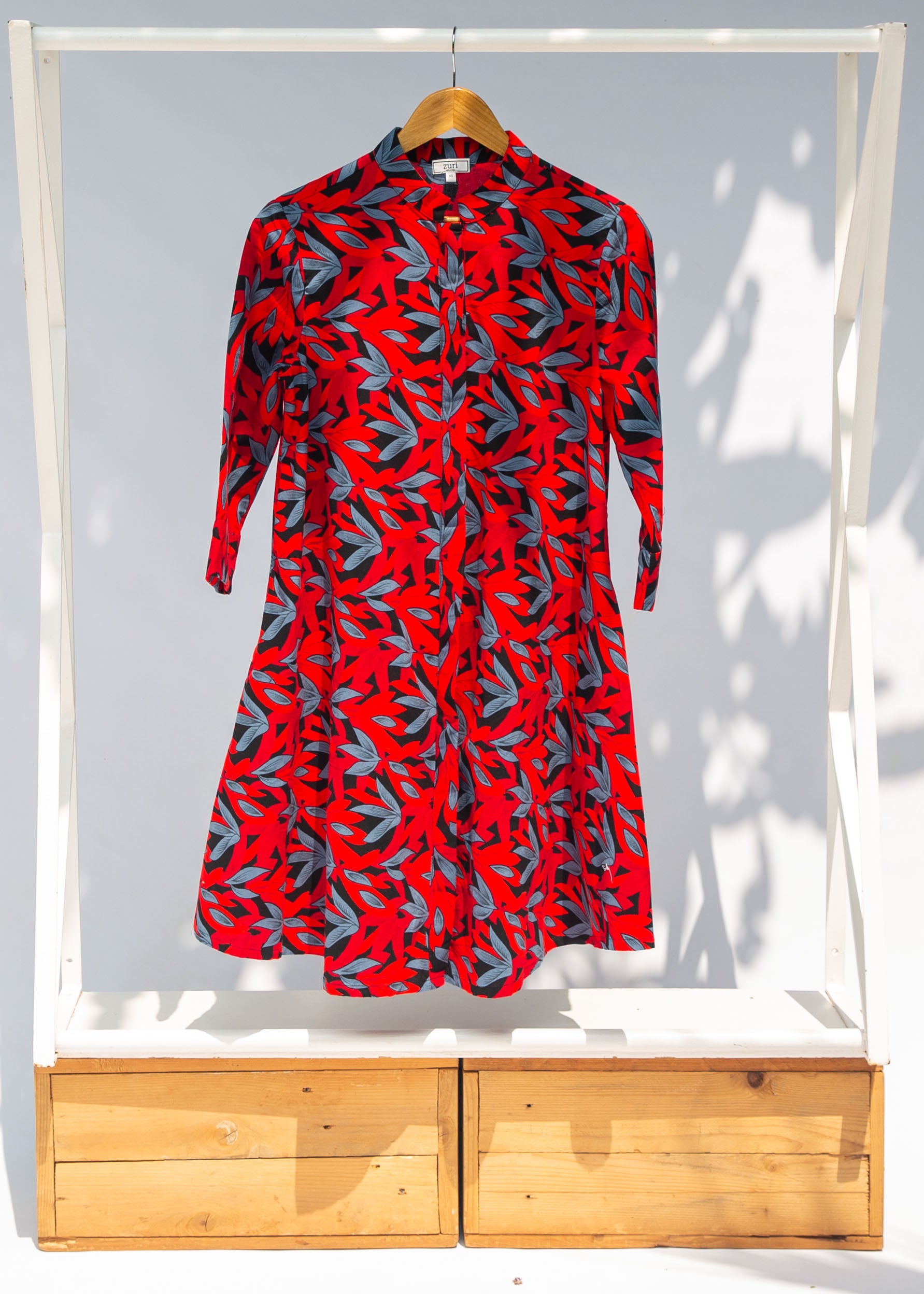 Display of red, black and gray leaf print dress.