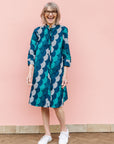 Model wearing circular grid print dress, with hues of blue.