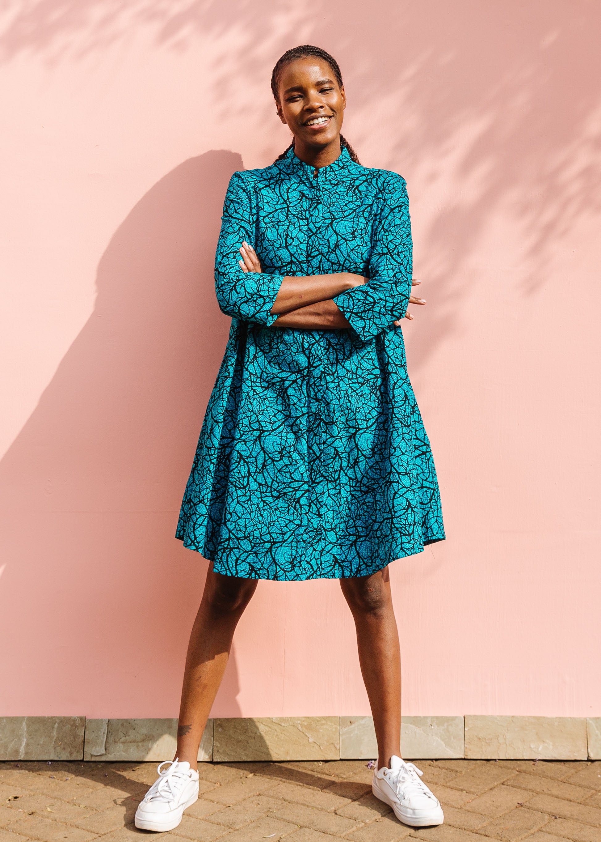 Model wearing blue dress with black abstract lines.