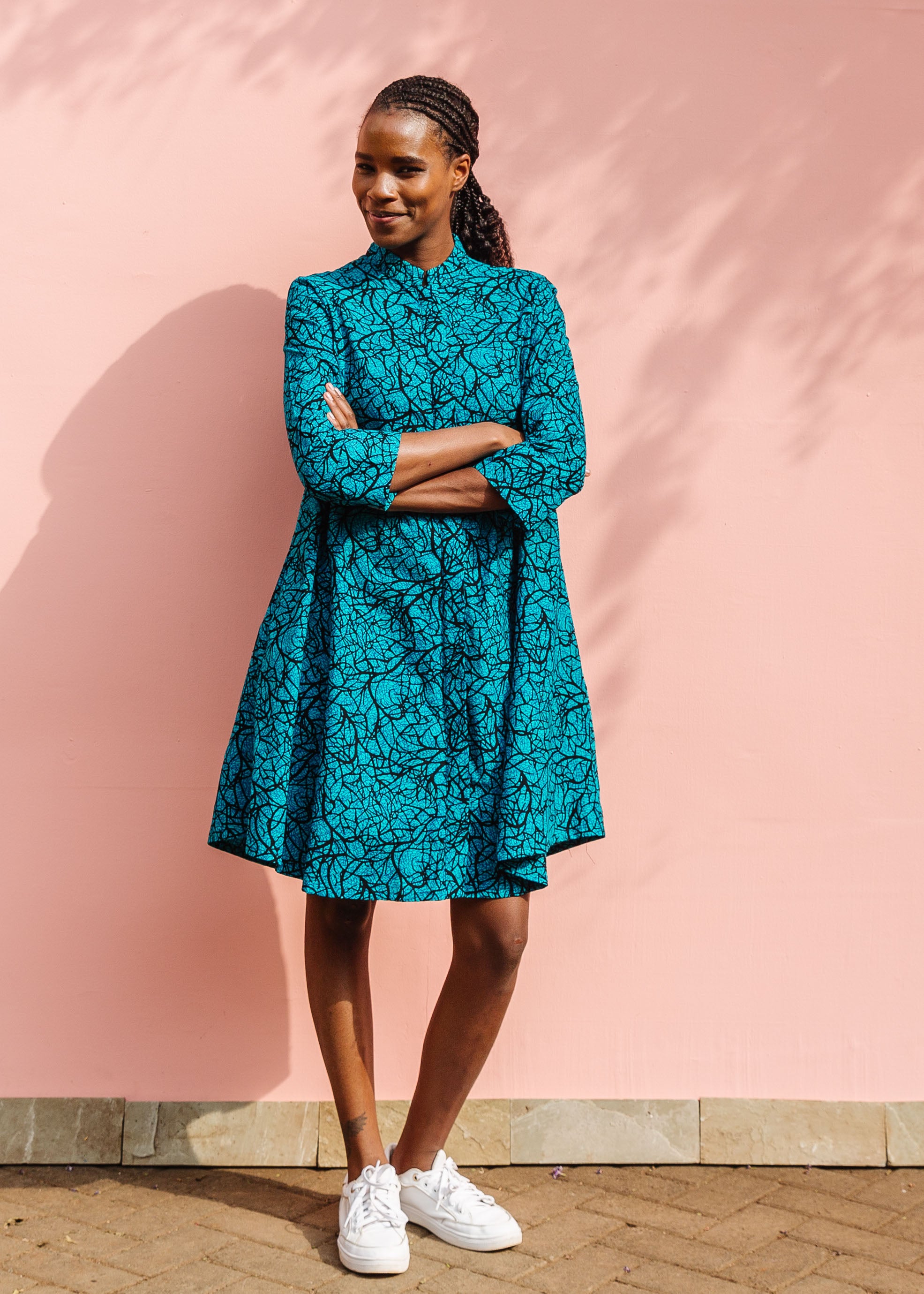 Model wearing blue dress with black abstract lines.