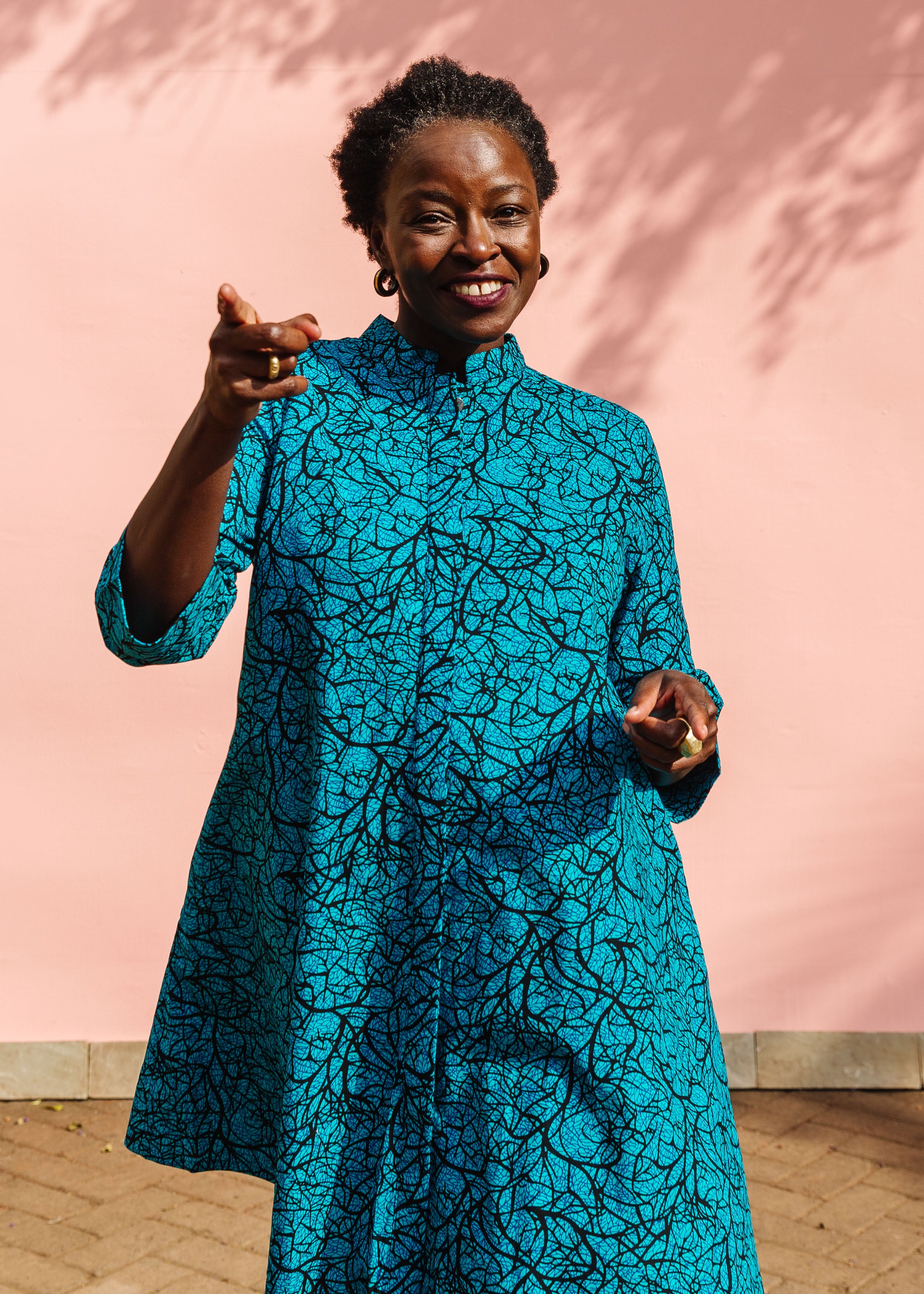 Model wearing blue dress with black abstract lines.