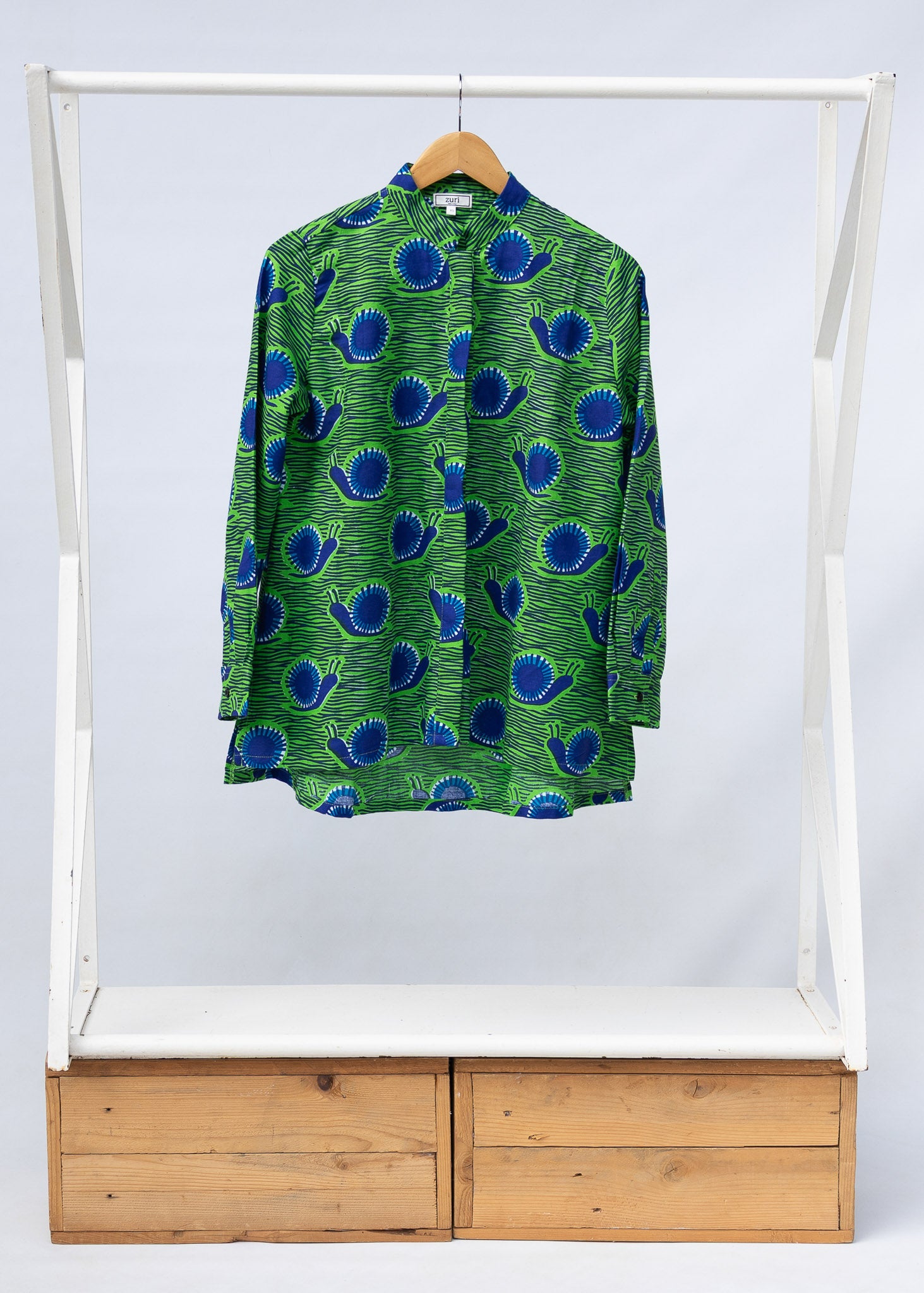 Display of green and blue snail print, long sleeved shirt.