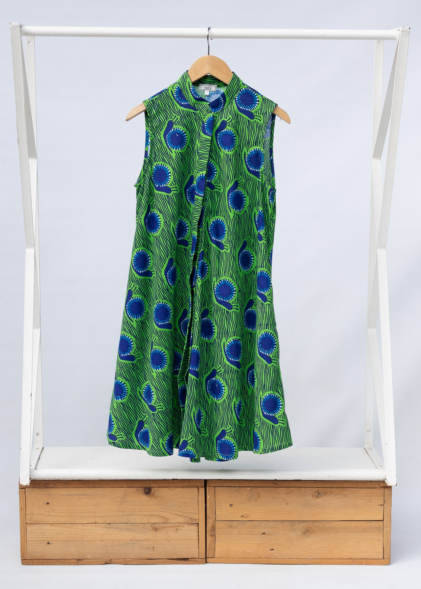 Display of sleeveless dress with green and blue snail print.