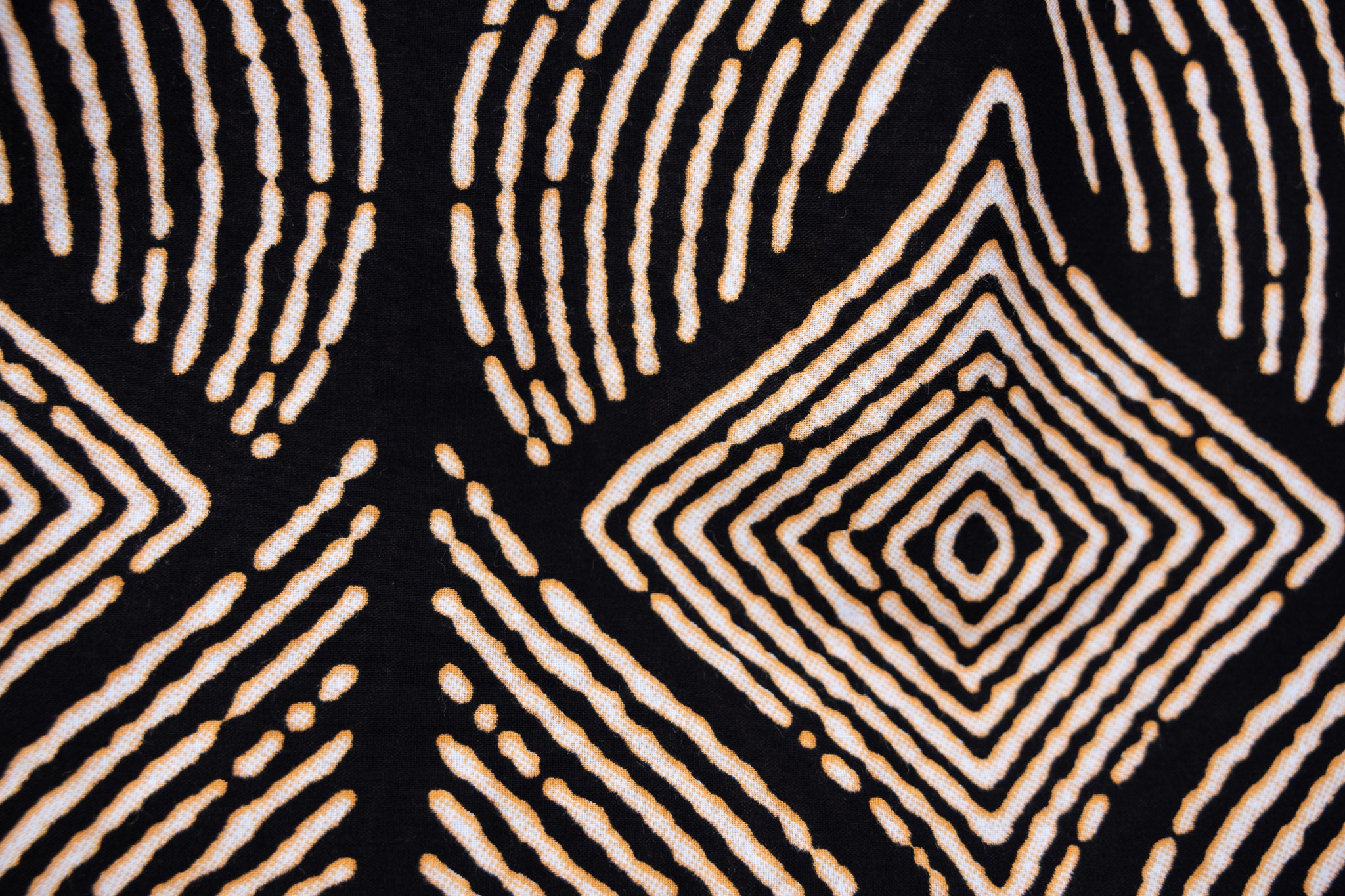 Close up display of black and beige abstract print blouse, fabric.