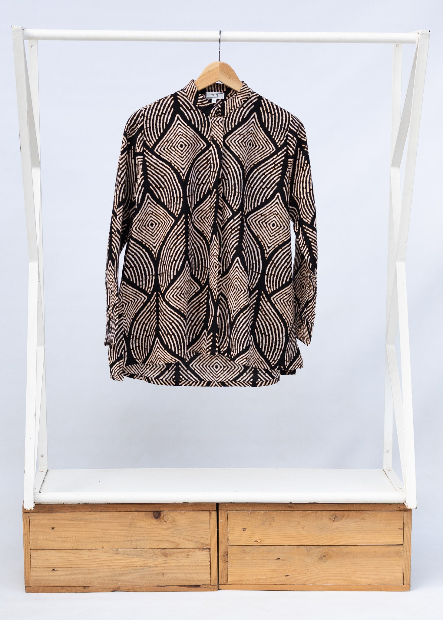 Display of black and beige abstract print blouse.