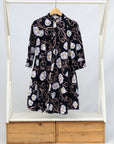 Display of black dress with pink and yellow floral print.