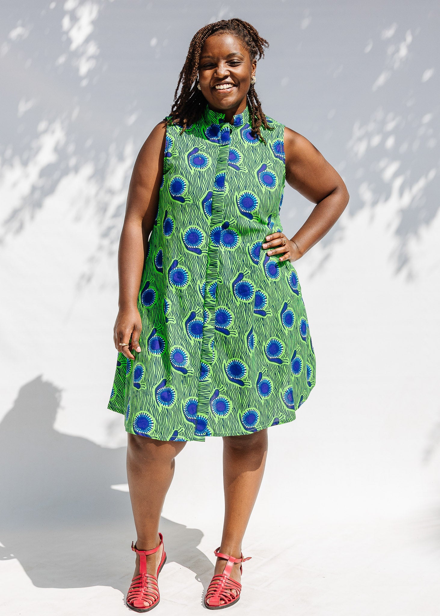 Model wearing sleeveless dress with green and blue snail print.