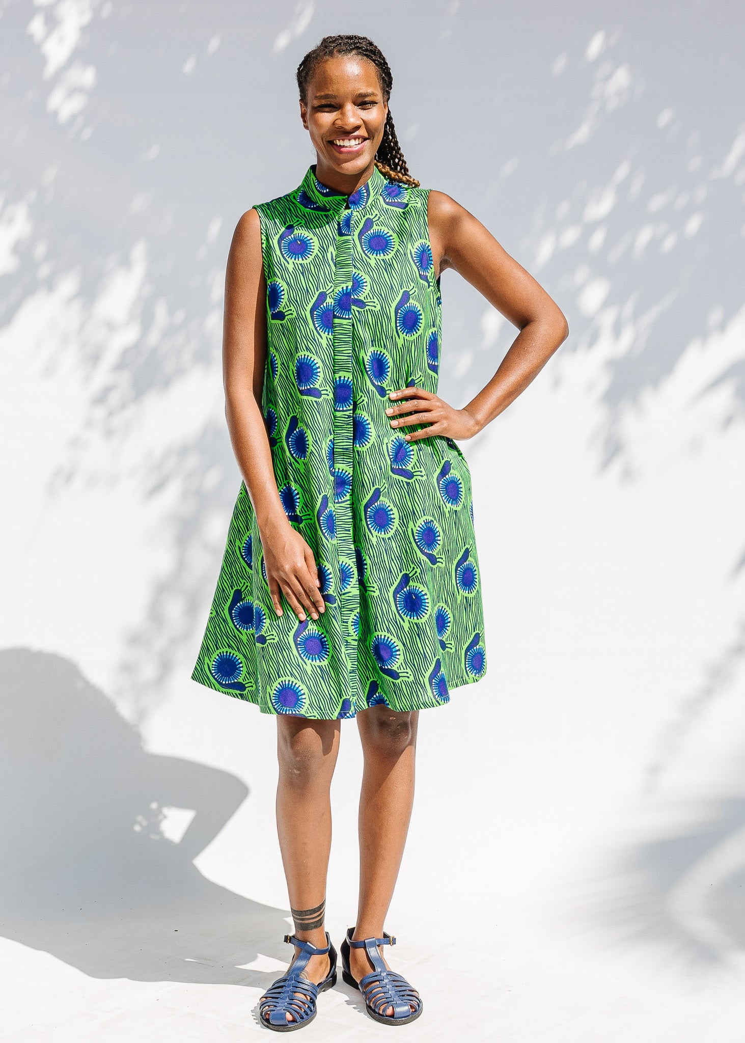 Model wearing sleeveless dress with green and blue snail print.