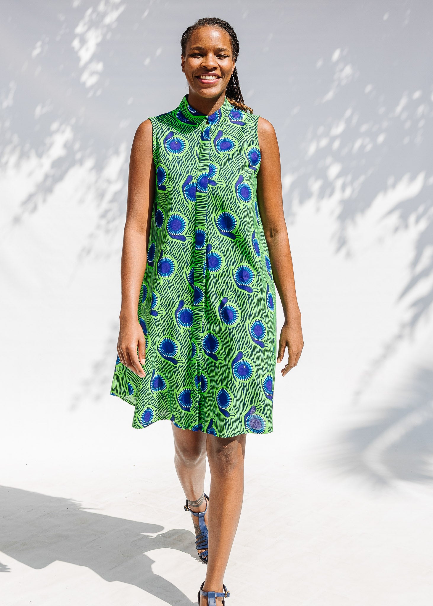 Model wearing sleeveless dress with green and blue snail print.