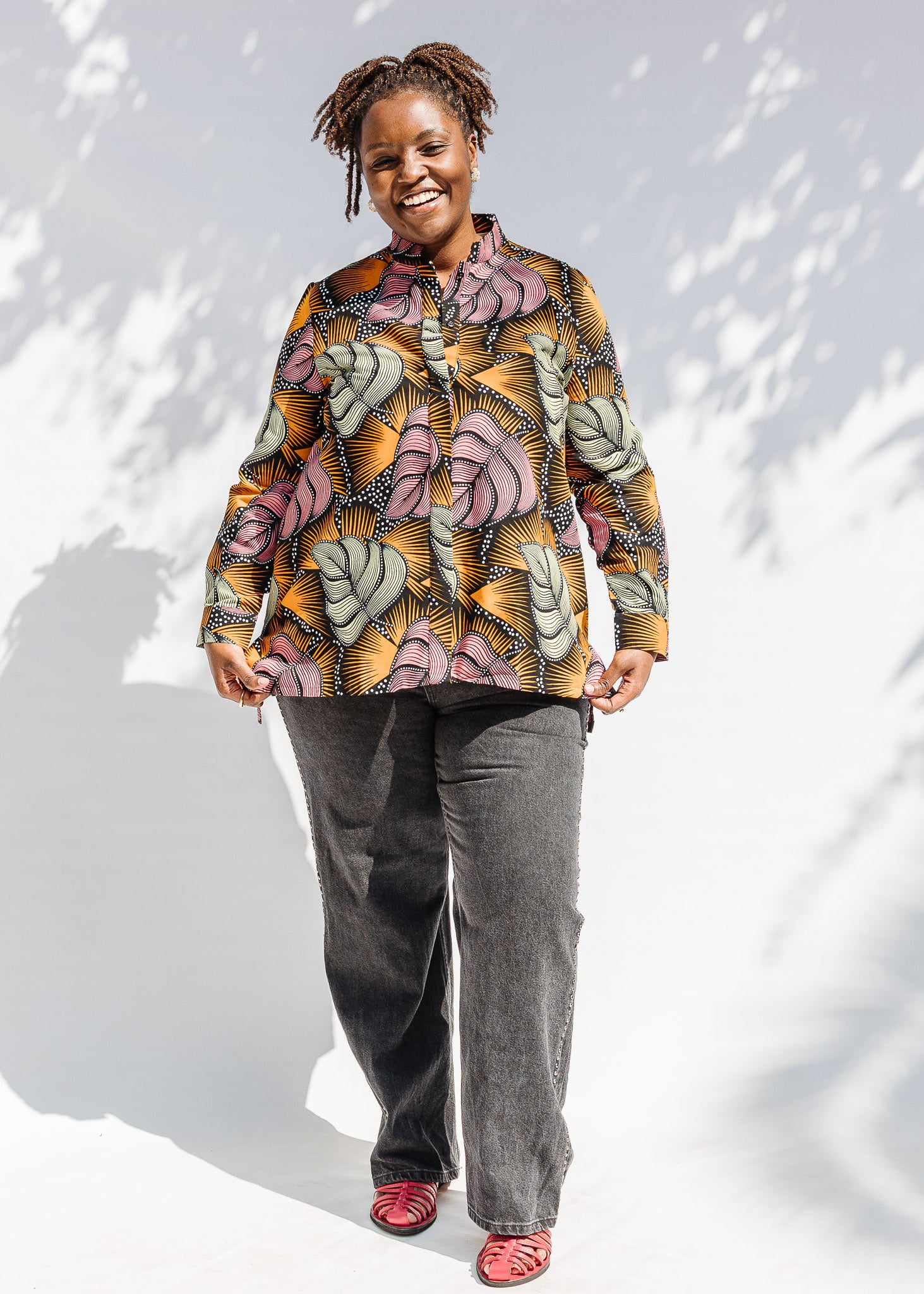 Model wearing orange and pink long sleeved blouse.
