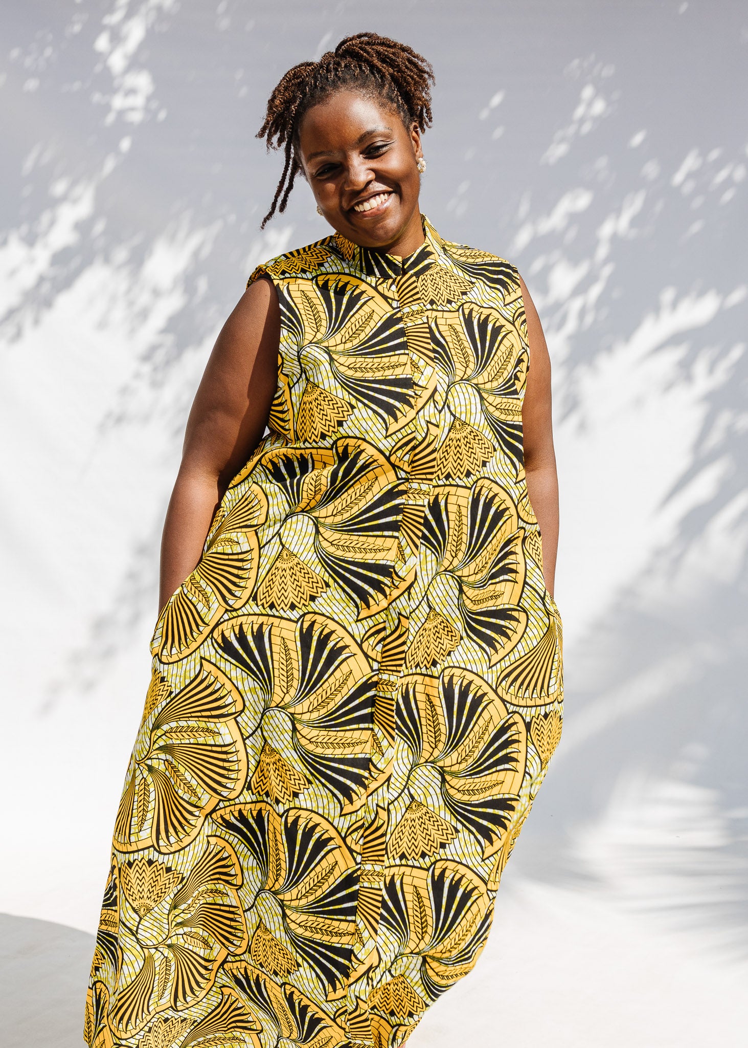 Model wearing yellow and black sleeveless maxi dress.