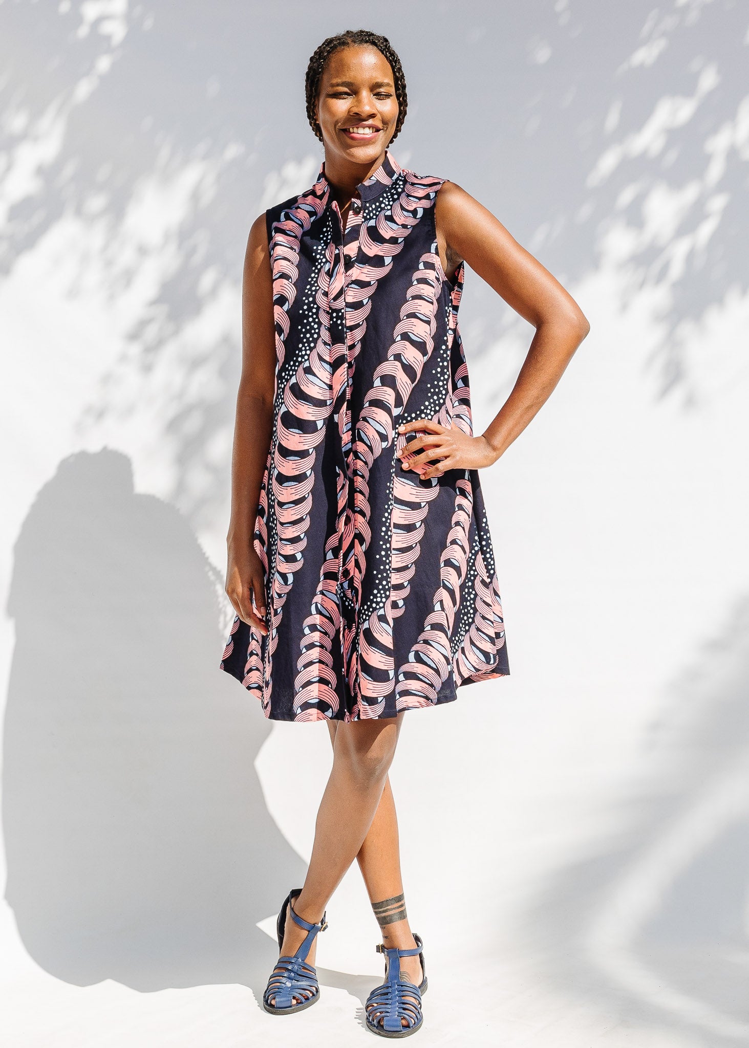 Model wearing black and pink sleeveless print dress.